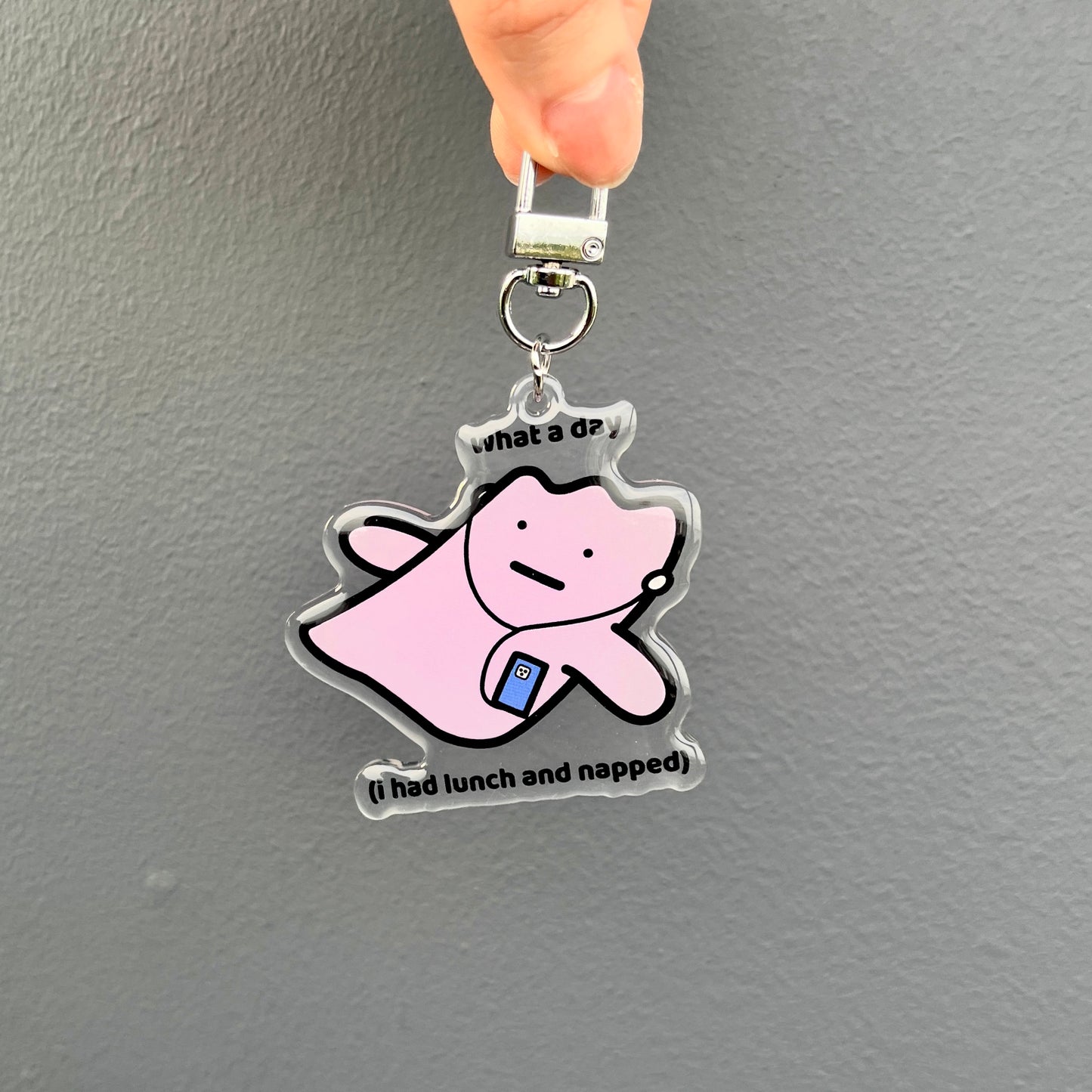 waterproof acrylic keychain with the text āWhat a day (I had lunch and napped)" on a plain background