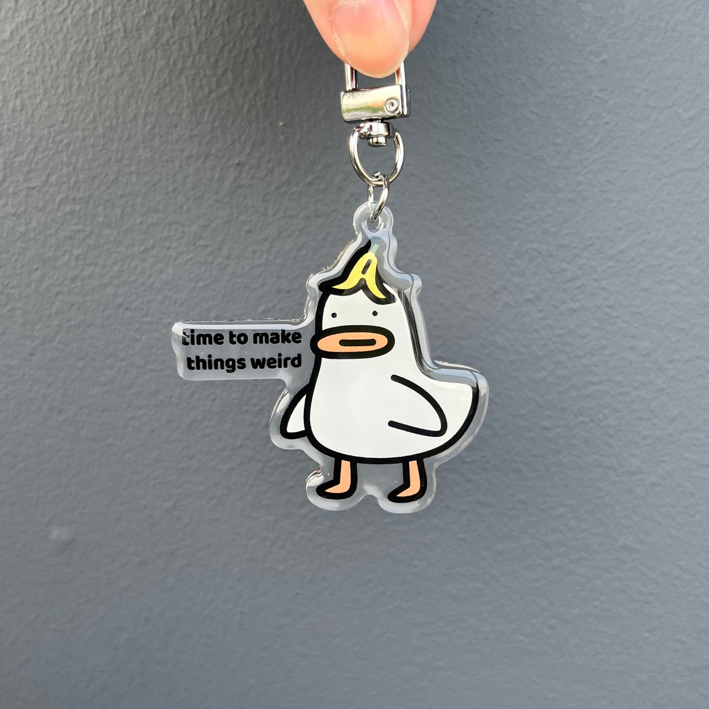 waterproof acrylic goose keychain with the text “Time to make things weird" on a plain background