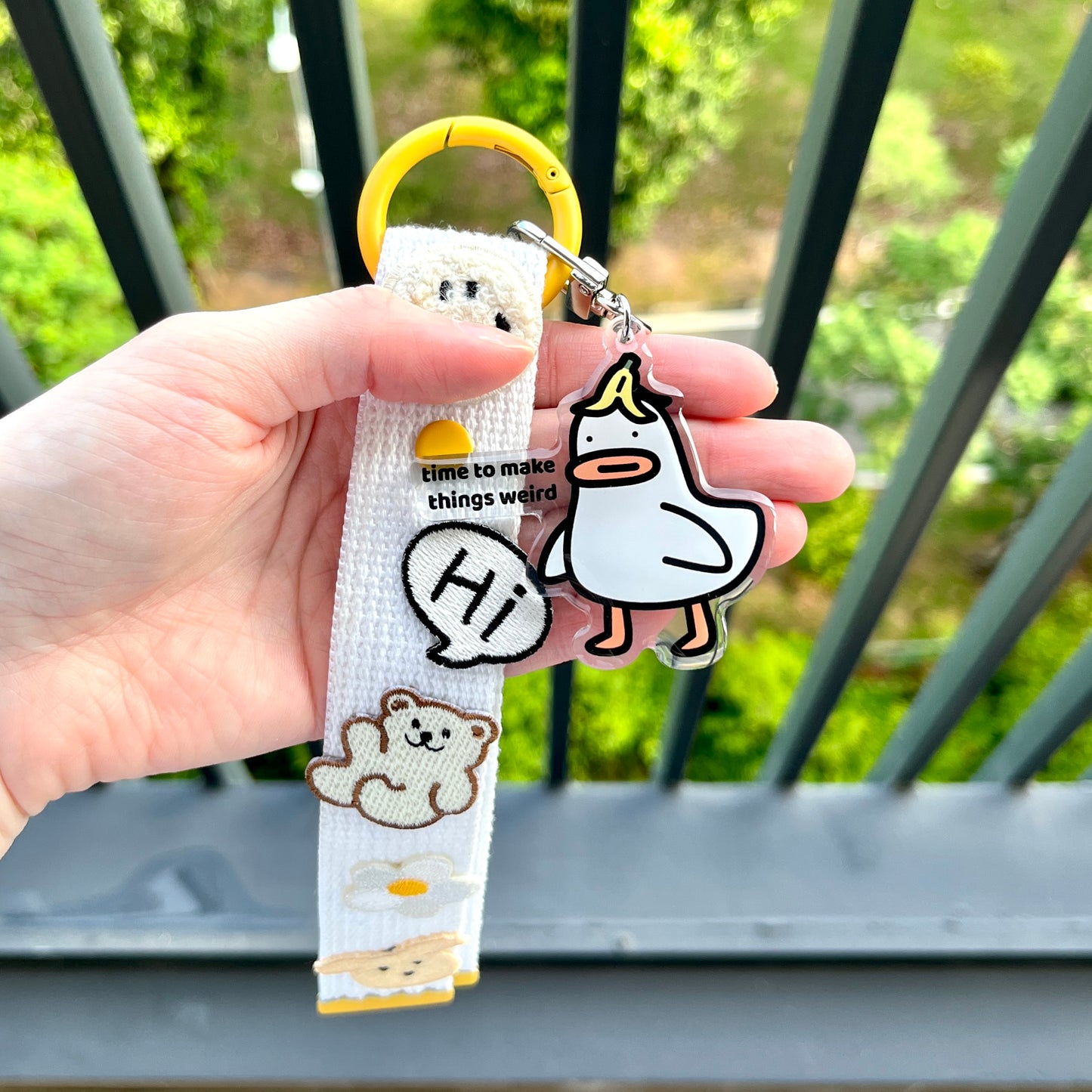 waterproof acrylic goose keychain with the text “Time to make things weird" on a person's hand