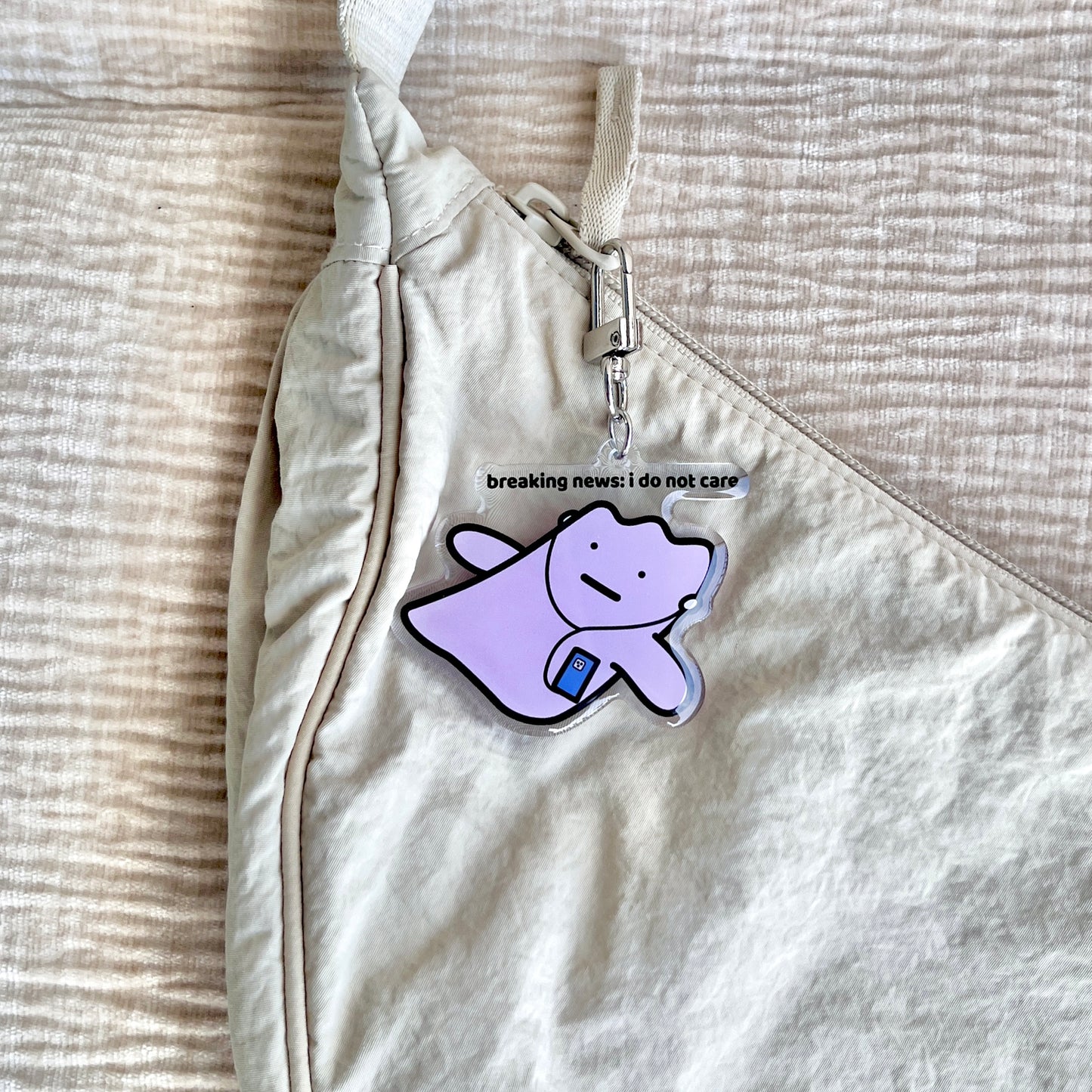 waterproof acrylic keychain with the text “Breaking news: I do not care" on a bag