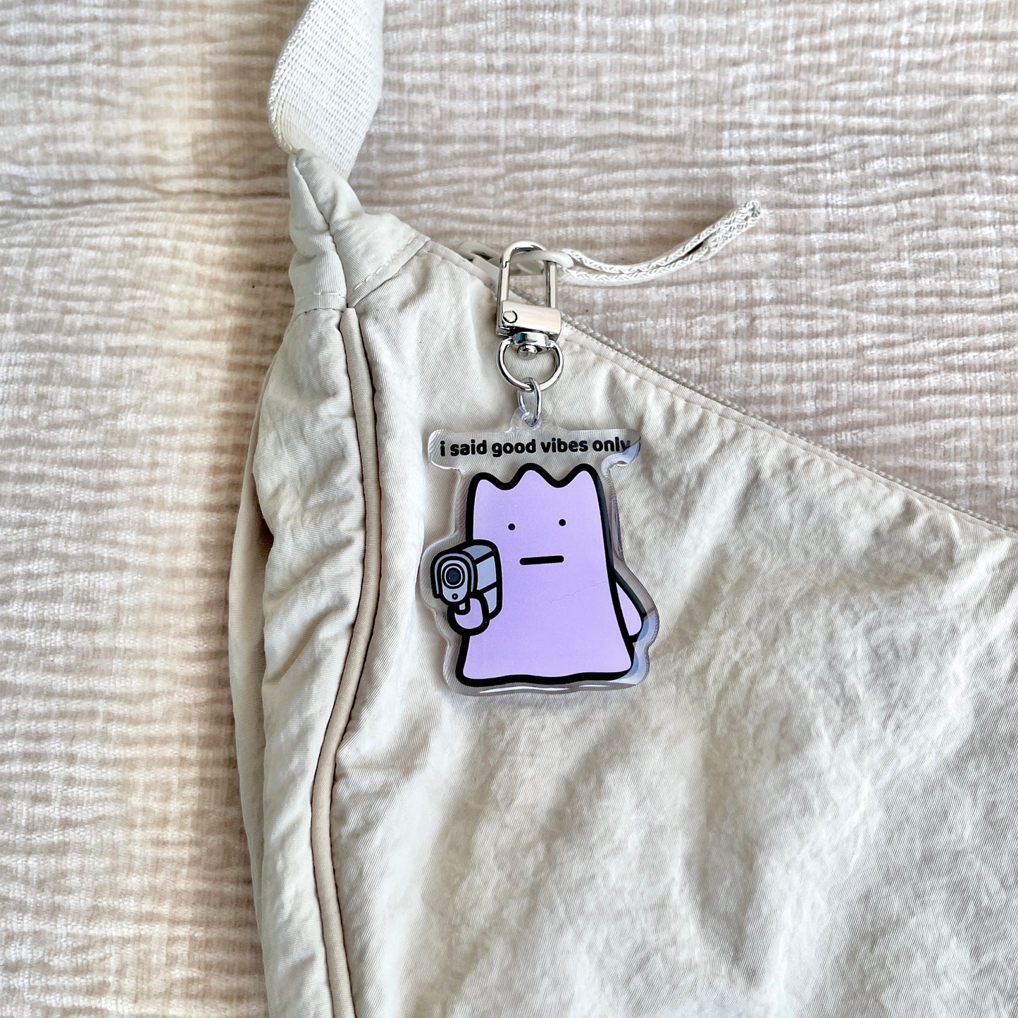 waterproof acrylic keychain with the text “I said good vibes only" on a bag