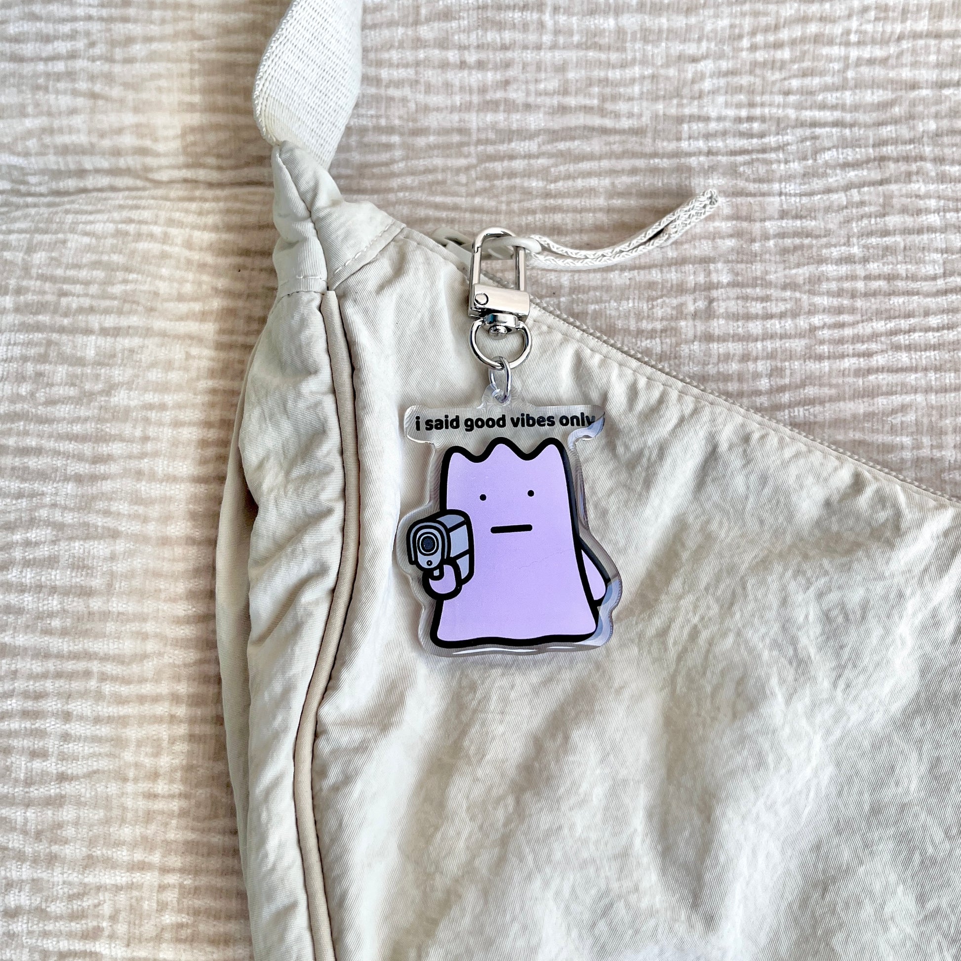 waterproof acrylic keychain with the text “I said good vibes only" on a bag