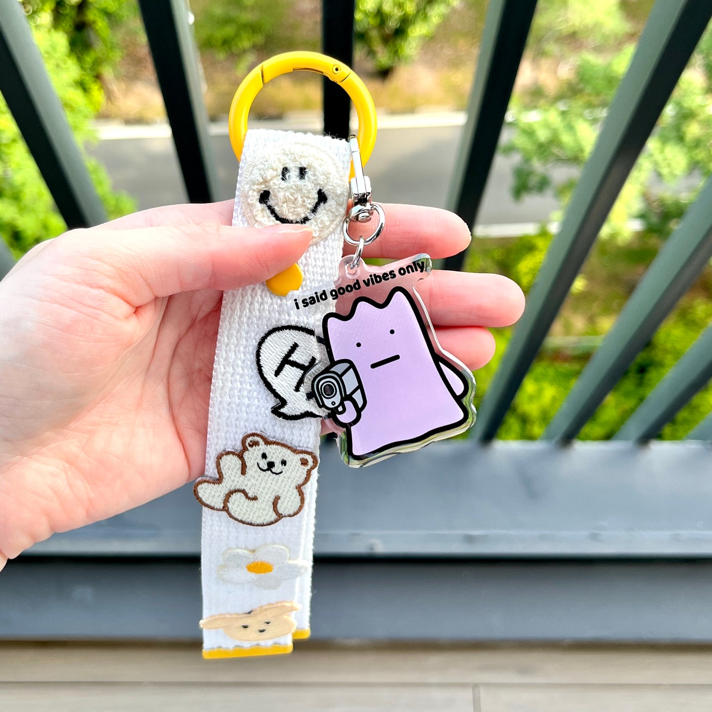 waterproof acrylic keychain with the text “I said good vibes only" on a person's hand