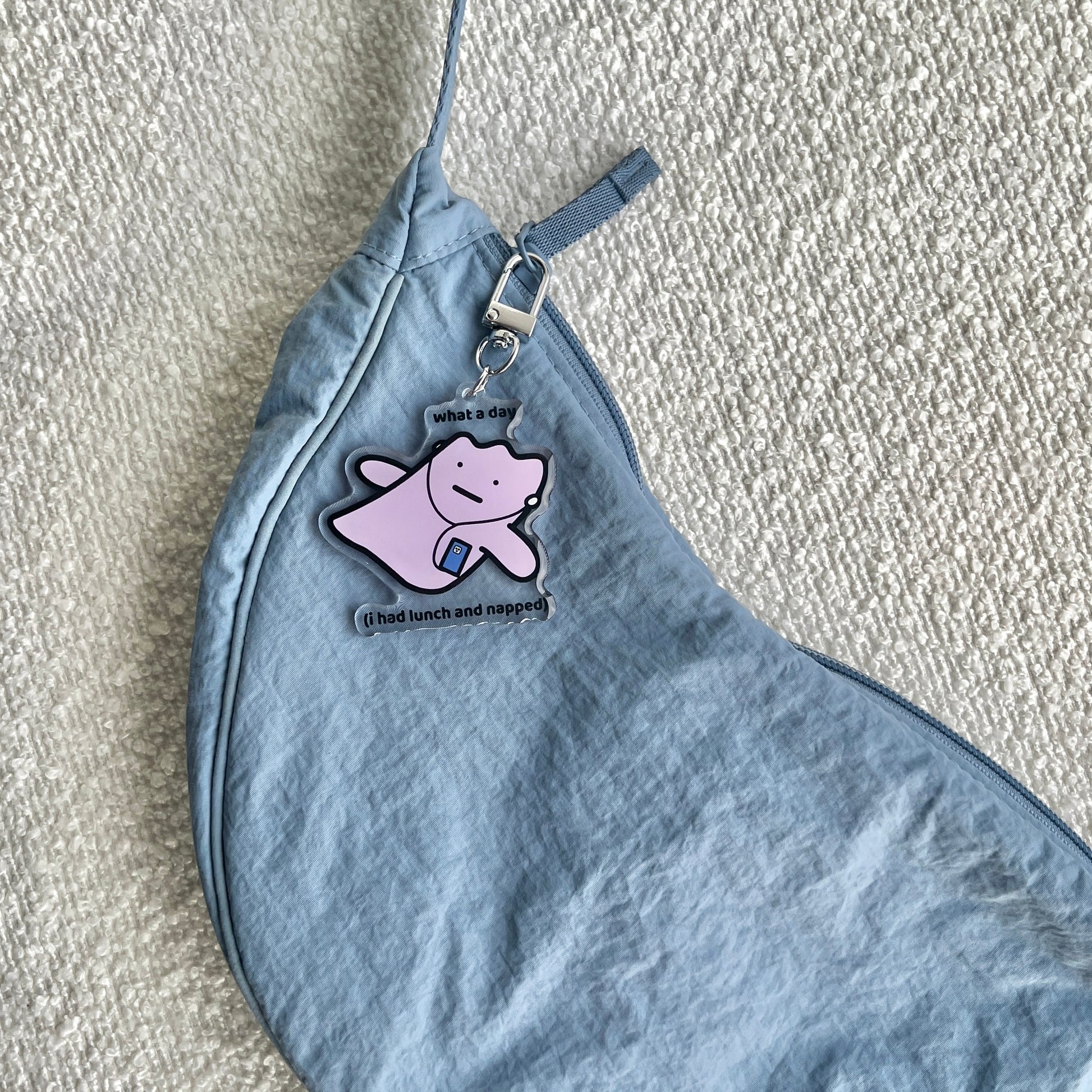 waterproof acrylic keychain with the text “What a day (I had lunch and napped)" on a bag