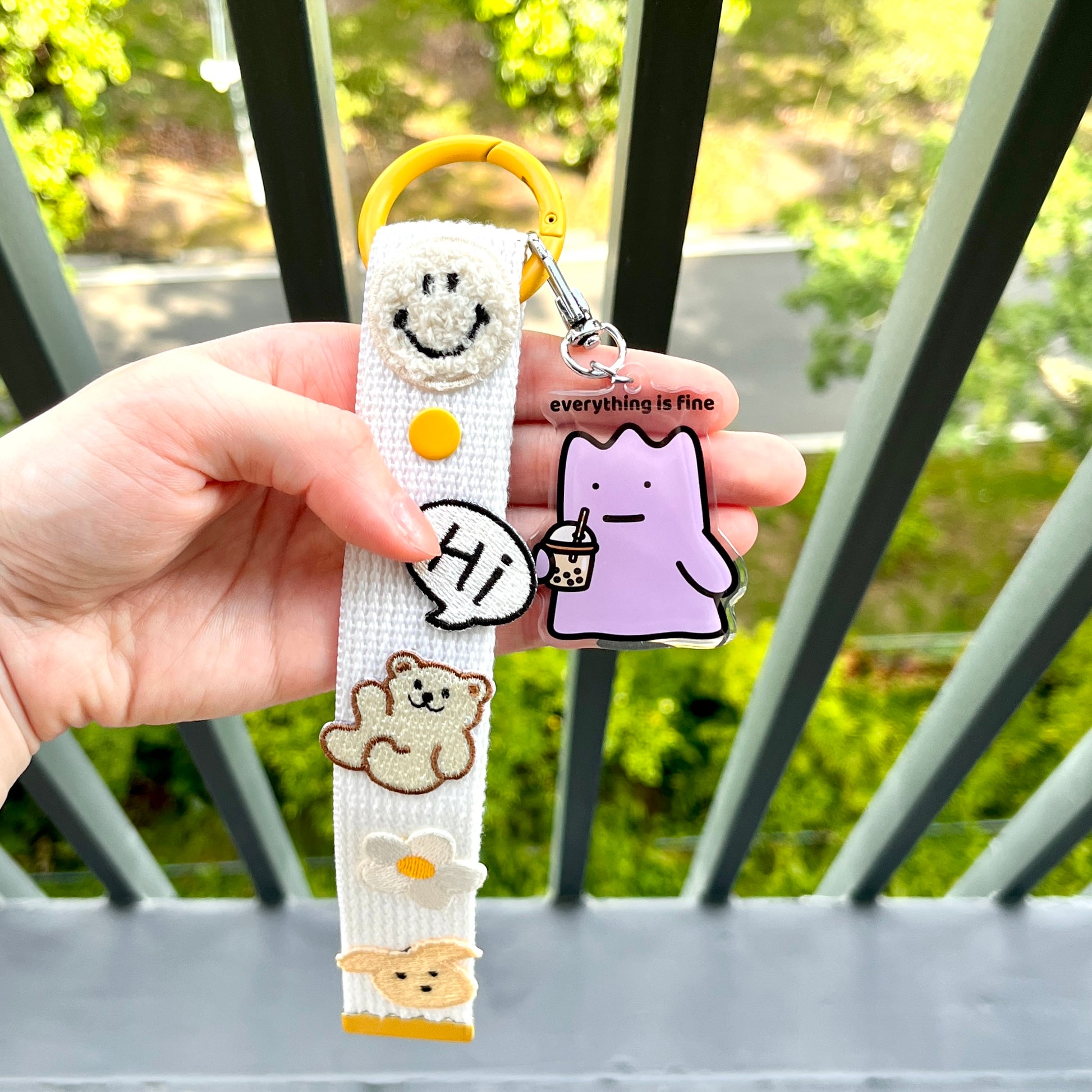 waterproof bubble tea acrylic keychain with the text “Everything is fine" on a person's hand