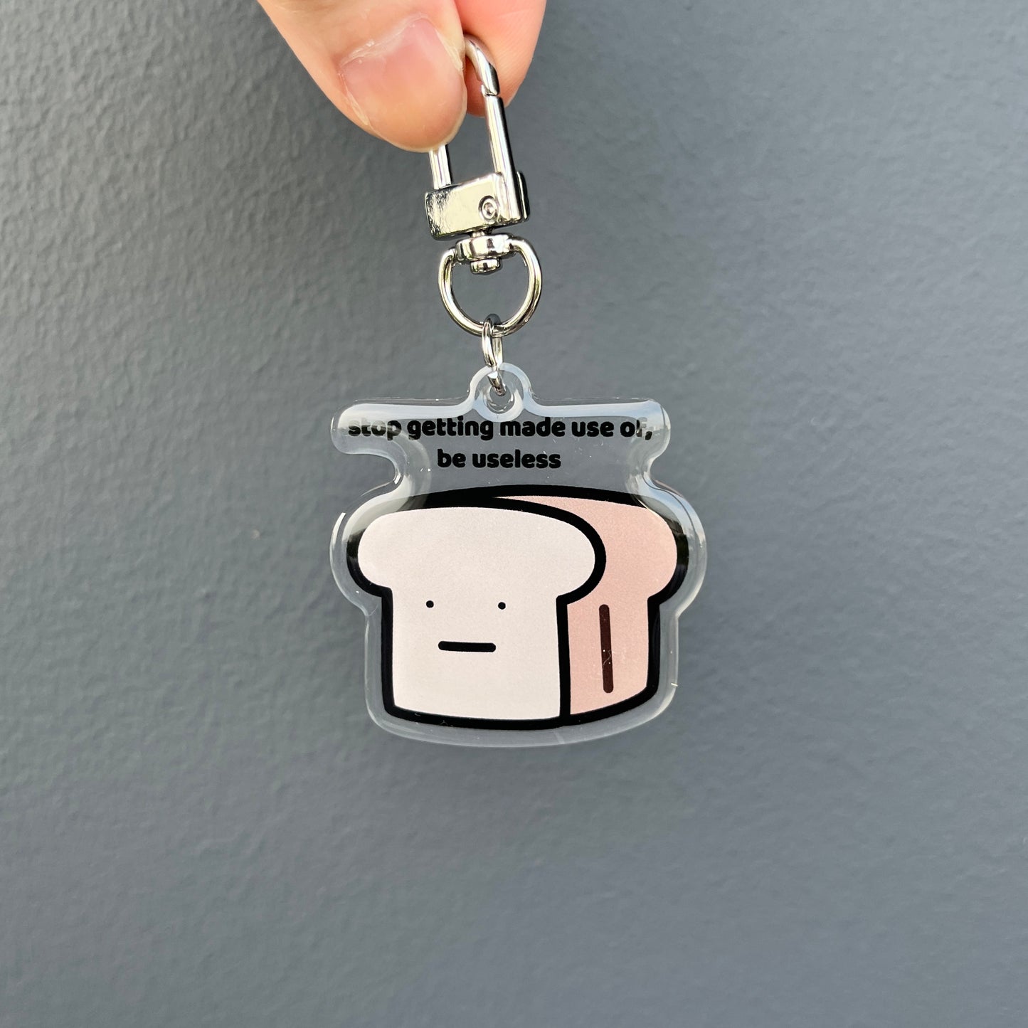 waterproof bread acrylic keychain with the text “Stop getting made use of, be useless" on a plain background