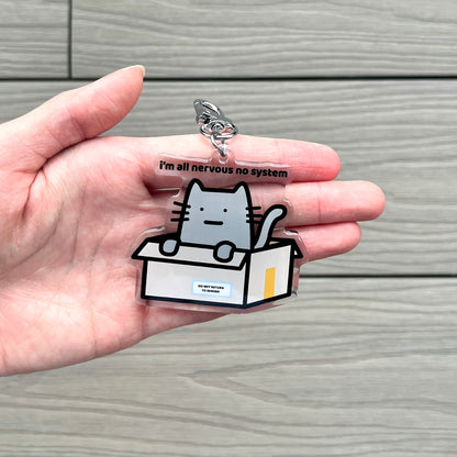 waterproof cat acrylic keychain with the text “I'm all nervous no system" on a person's hand