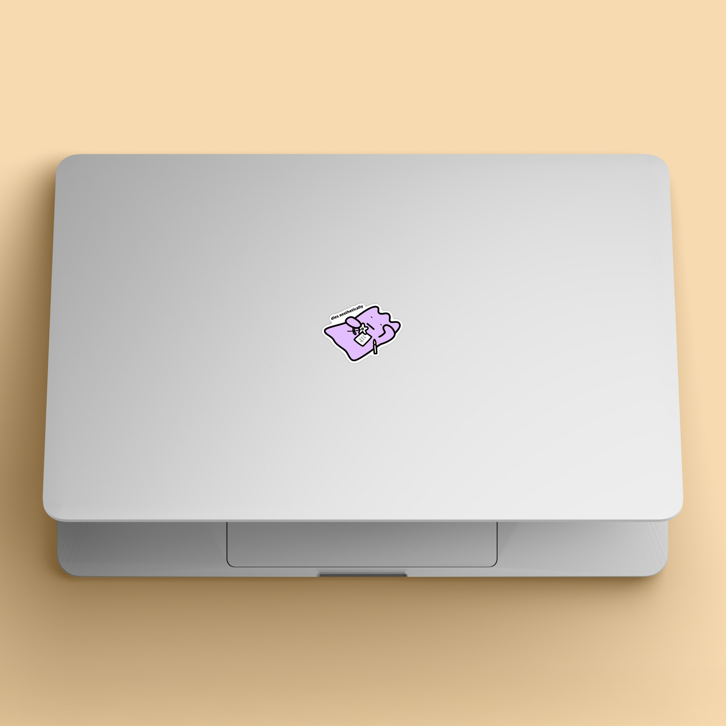waterproof vinyl sticker with the text “Dies aesthetically" on a laptop