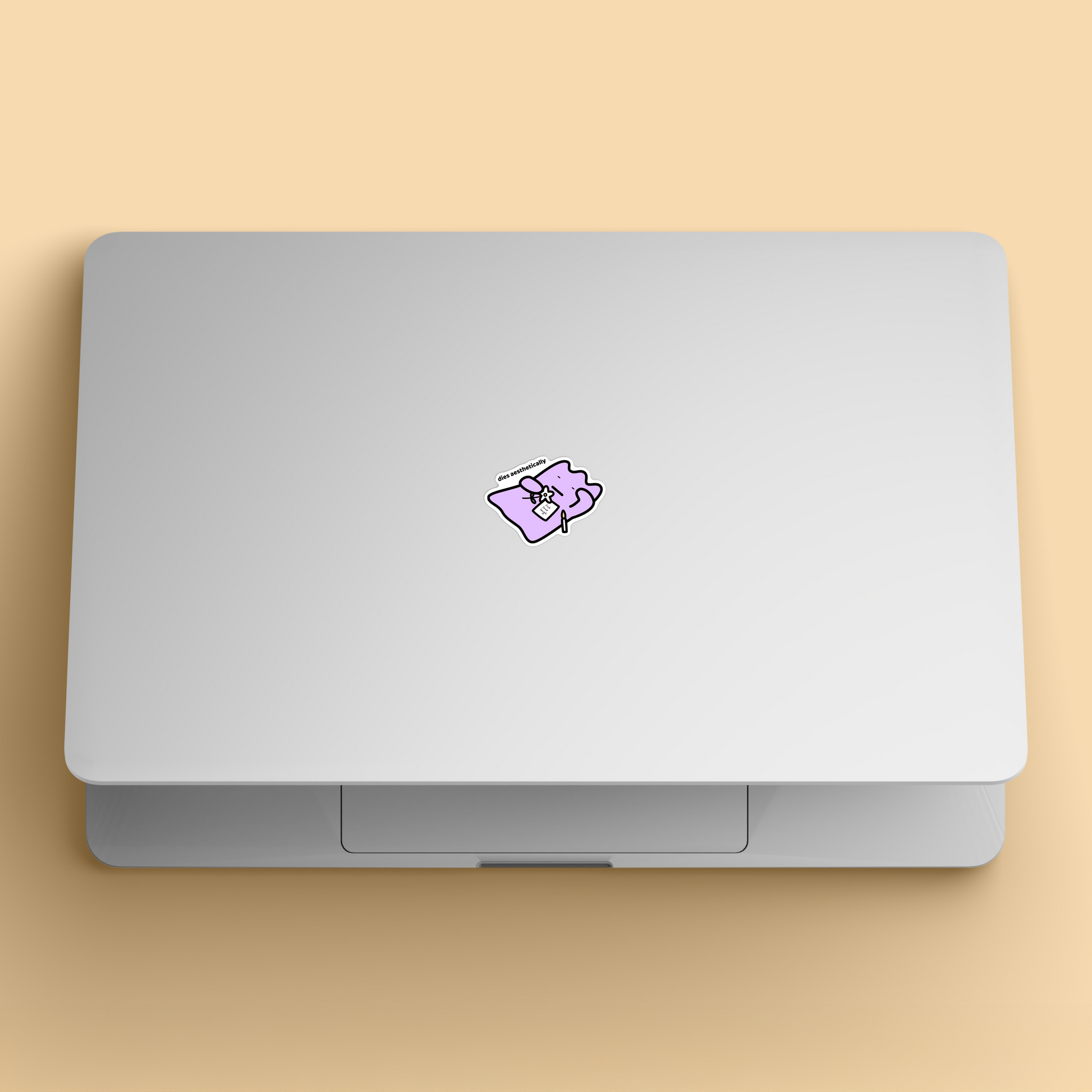 waterproof vinyl sticker with the text “Dies aesthetically" on a laptop