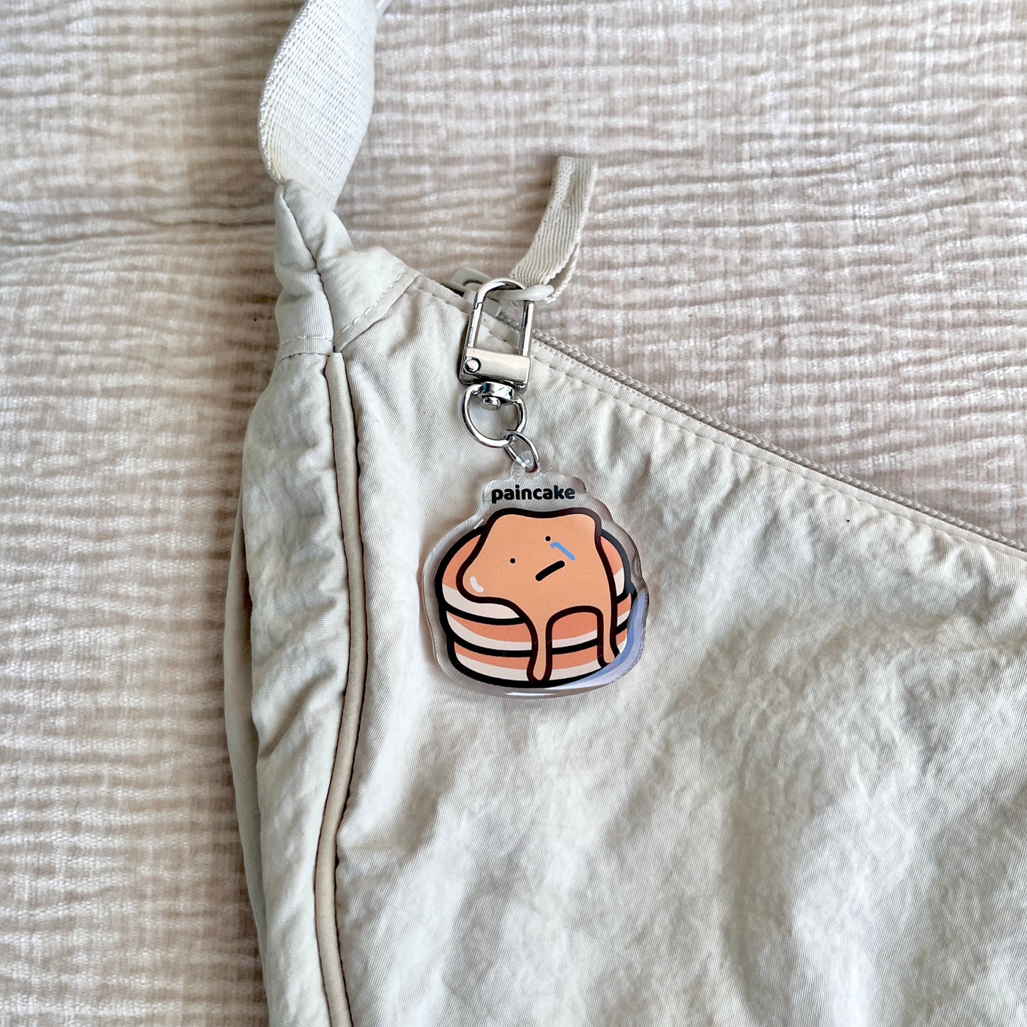 waterproof pancake acrylic keychain with the text “Paincake" on a bag