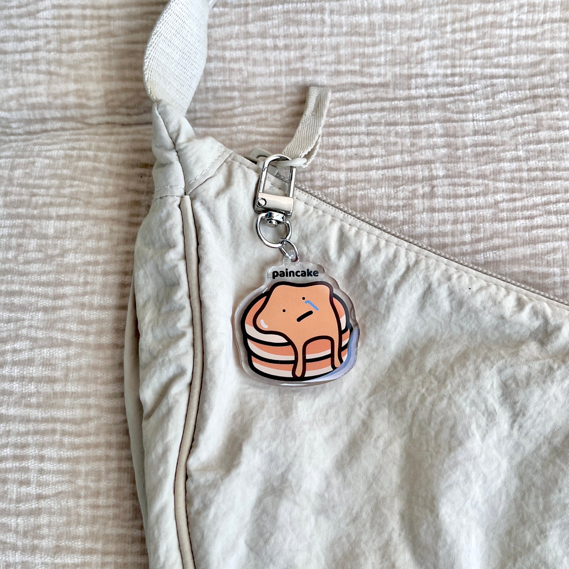 waterproof pancake acrylic keychain with the text “Paincake" on a bag