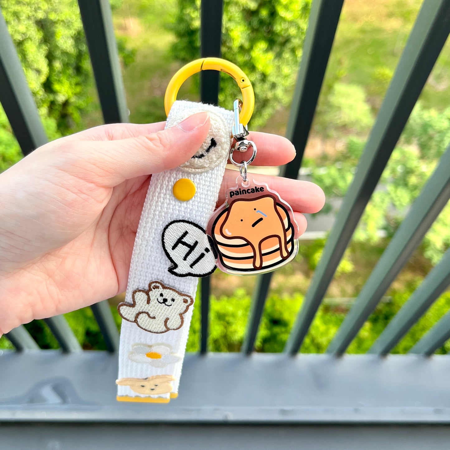 waterproof pancake acrylic keychain with the text “Paincake" on a person's hand